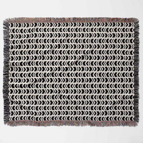 Black and white retro arrow lines woven blanket throw tapestry with fringed edges flat lay on a light gray background