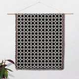 Black and white retro checker woven blanket throw tapestry as wall hanging on a white background