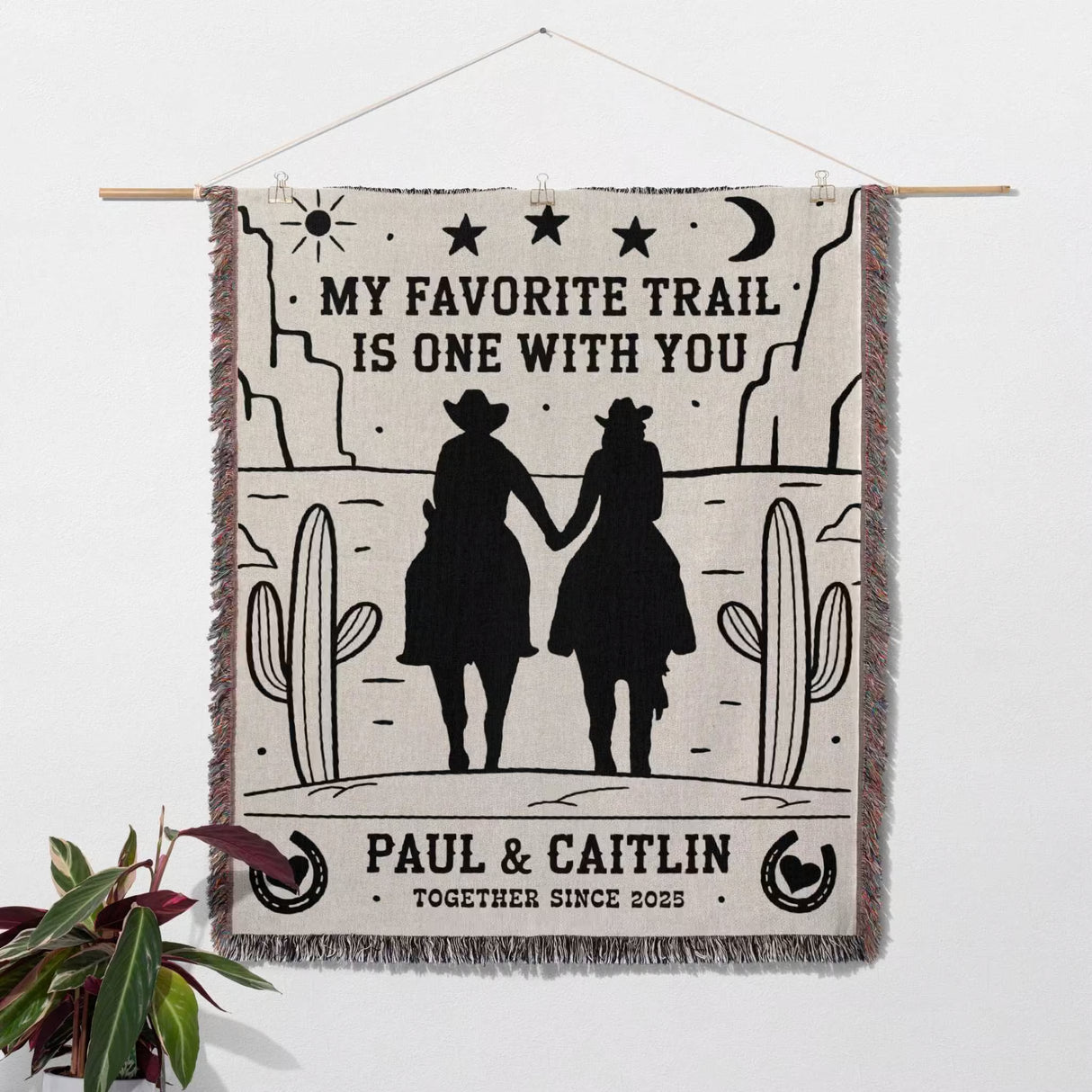 Romantic cowboy and cowgirl cotton anniversary gift – woven throw blanket with cowboy design and text, hanging on a wall.