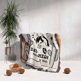 Romantic western cotton anniversary gift - woven throw blanket with graphic design draped over a chair next to a plant and decorative items.