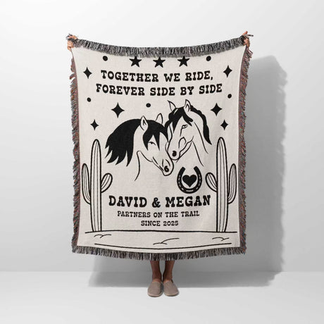 Romantic western cotton anniversary gift - woven throw blanket with horse design and text held by a person on a white background