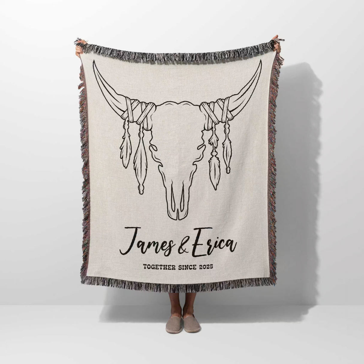 Rustic bull skull cotton anniversary gift woven throw blanket held by a person with bull skull design and personalized text on a white background