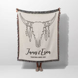 Rustic bull skull cotton anniversary gift woven throw blanket held by a person with bull skull design and personalized text on a white background