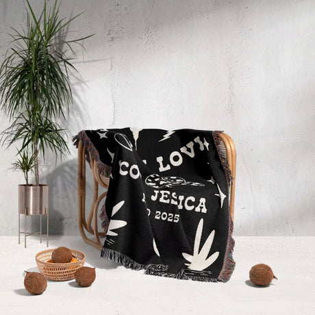 Rustic western 2nd anniversary gift woven throw blanket with white designs draped over a chair in a room with a plant and decorative items.
