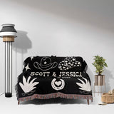 Rustic western 2nd anniversary gift woven throw blanket with white designs and text on a sofa in a room with a lamp and plant.