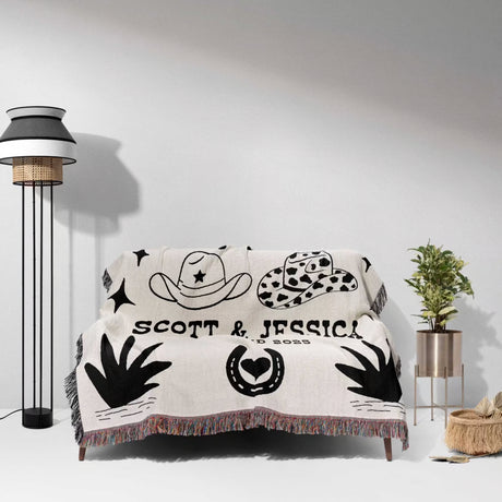 Rustic western cotton anniversary gift woven throw blanket with personalized design on a couch in a room with decor elements.