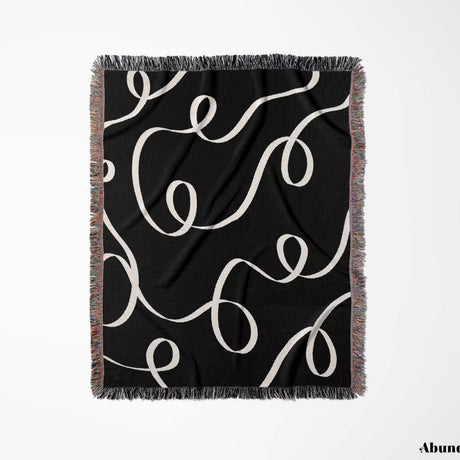 Black and white scribble lined woven blanket throw with fringe full view on a white background.