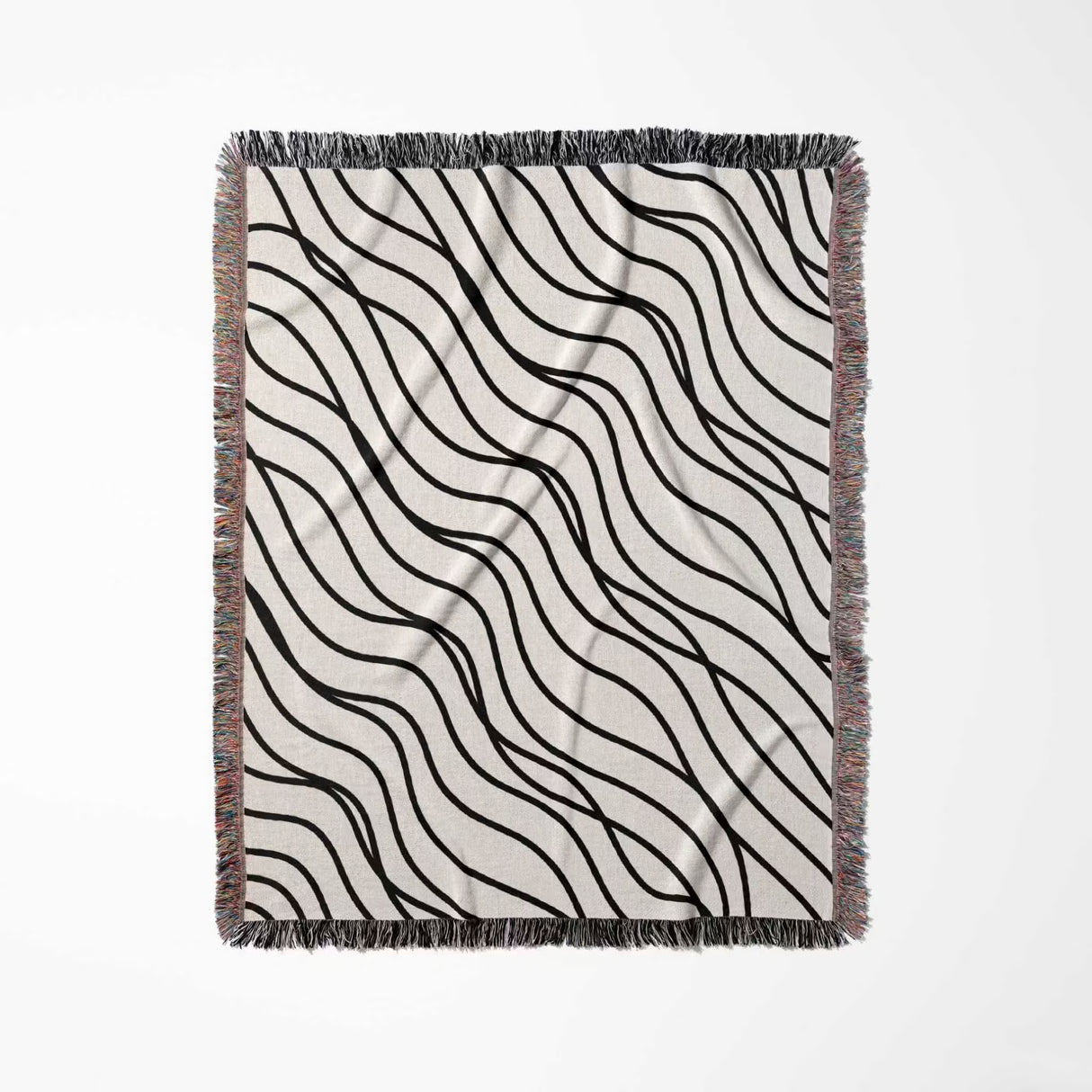 Black and white simple curly lines woven blanket throw flat lay on a white background.