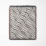 Black and white simple curly lines woven blanket throw flat lay on a white background.