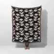 Black and white patterned throw blanket draped over a person on a white background