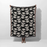 Black and white patterned throw blanket draped over a person on a white background