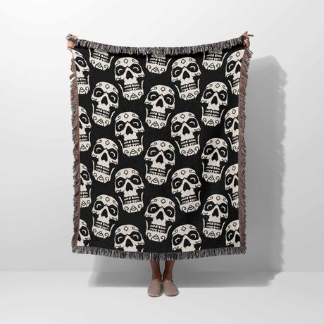 Black and white patterned throw blanket draped over a person on a white background