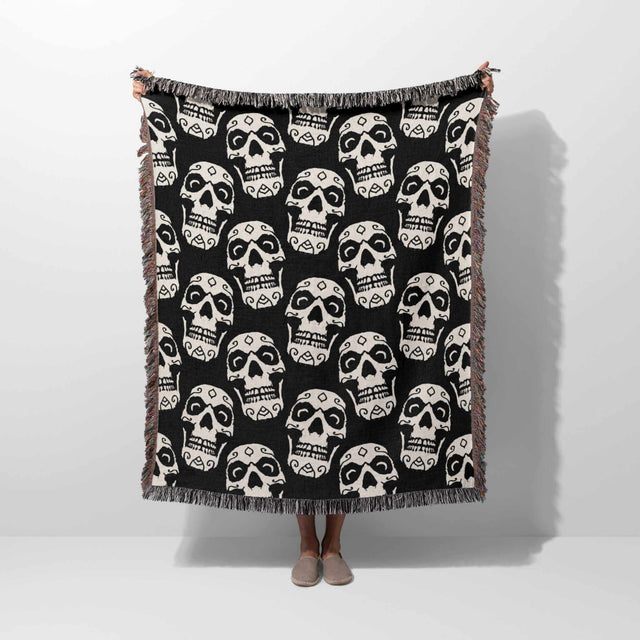 Black and white patterned throw blanket draped over a person on a white background