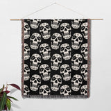 Black and white geometric patterned blanket hanging on a wooden rod against a white background.