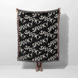 Black blanket with 'spooky' text pattern draped over a person on a white background