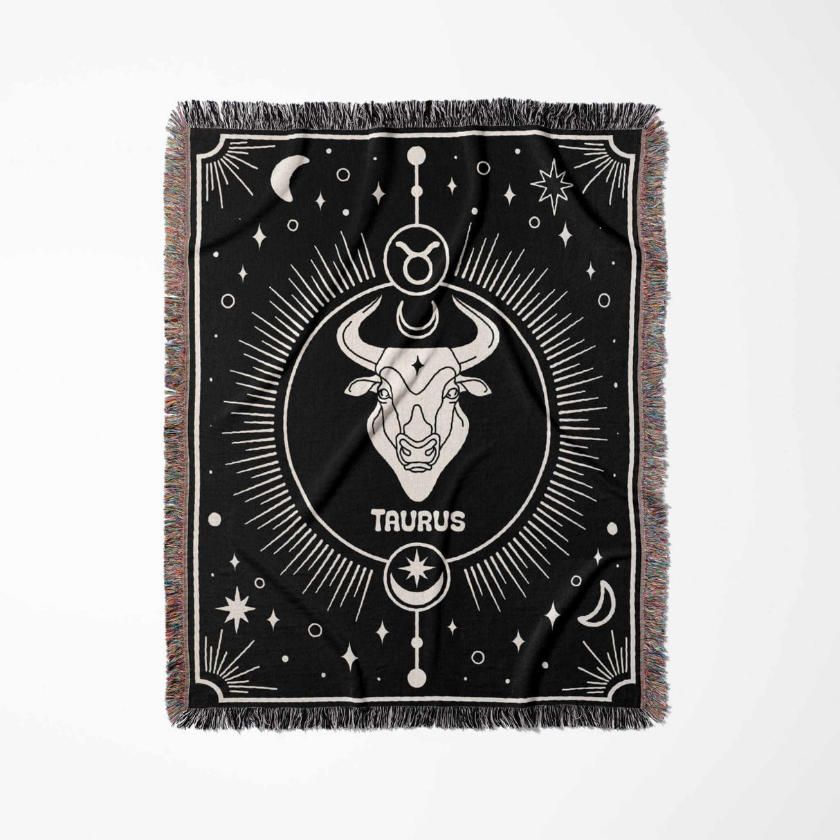 Flat vertical view of the Taurus Zodiac Blanket showcasing its complete design. The woven throw blanket in black and white highlights the Taurus zodiac sign and celestial decorations with a vibrant multicolor fringe.