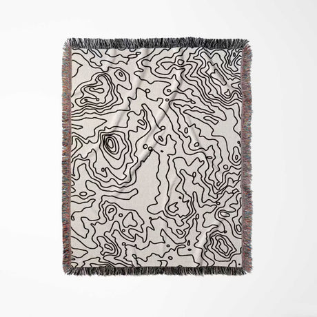Black and white topographic map design woven throw blanket full view on a white background.