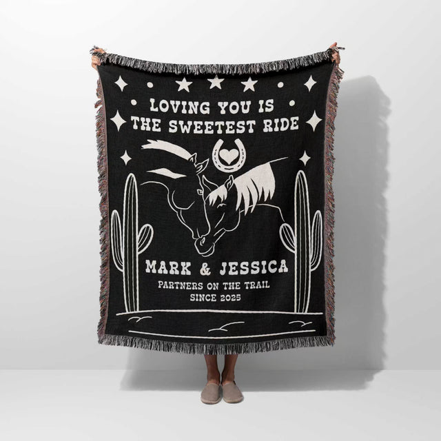 Two horses 2nd anniversary gift woven throw blanket with white text and graphics, featuring a horse and cactus design, held by a person.