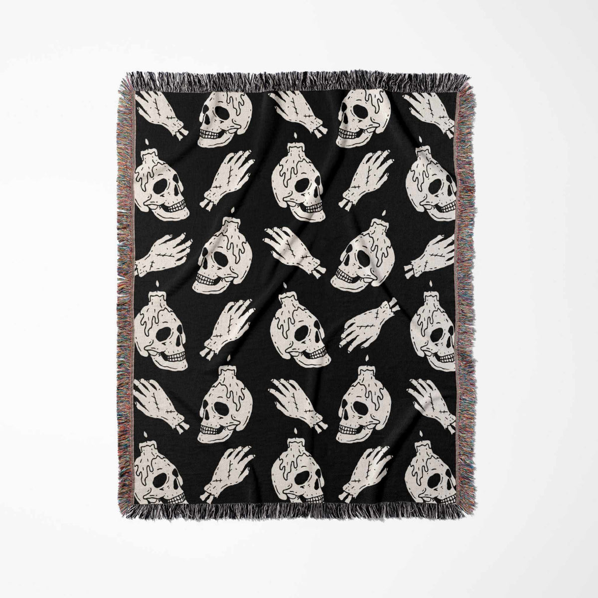 Black blanket with white skull and hand designs on a white background