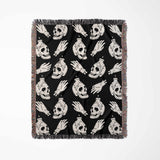 Black blanket with white skull and hand designs on a white background