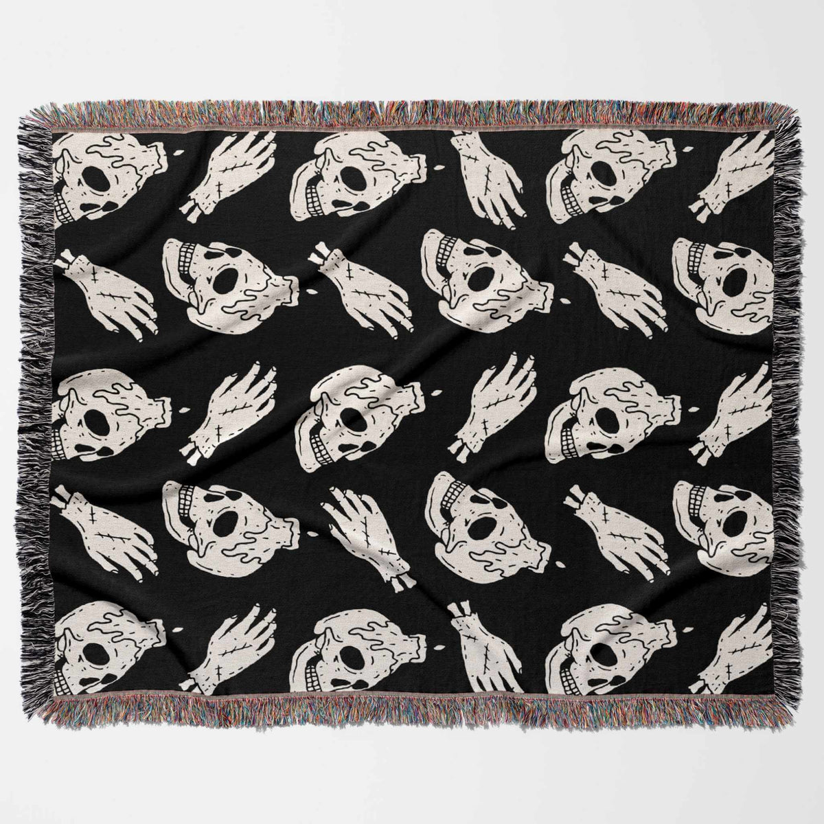 Black blanket with white skull and hand pattern on a white background