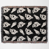 Black blanket with white skull and hand pattern on a white background