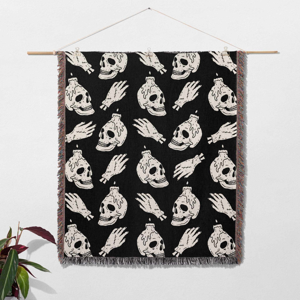 Blanket with skull and hand pattern hanging on a wall