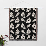 Blanket with skull and hand pattern hanging on a wall