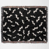 This image presents the Halloween blanket laid flat horizontally, showcasing the entire bat pattern spread evenly across the black background. The blanket features a border with multicolored fringes that frame the design, offering a complete view of its texture and pattern.