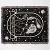 This image shows a flat lay of a Zodiac Sign Blanket, presenting the Aquarius astrological sign. The woven tapestry blanket features a black-and-white design with constellation and celestial motifs. Perfect for adding a personalized touch to any room, it combines comfort with astrological elegance.