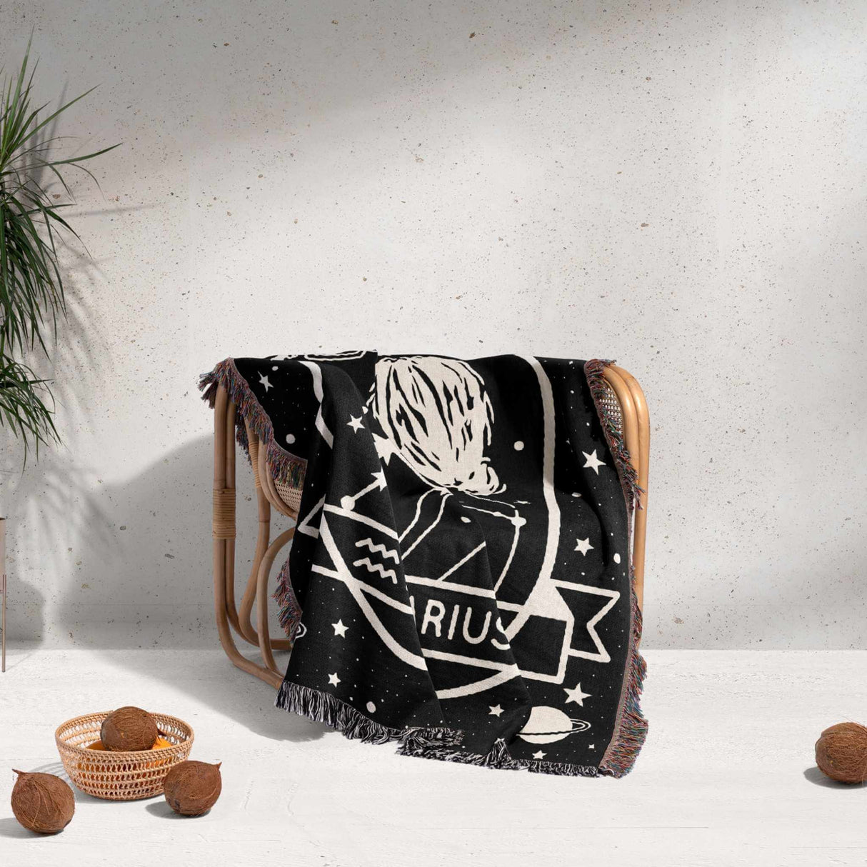 This image presents a Zodiac Sign Blanket draped over a chair, featuring the Aquarius astrological sign. The woven throw tapestry showcases a detailed illustration with stars and constellations. Perfect for home decor or as a cozy throw, it combines functionality with astrological beauty.